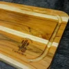 Tres tablas rectangulares de madera apiladas de forma escalonada, grabadas en láser con el logo de un cactus y el texto "La Ventana Cantaritos".
