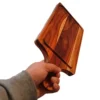 Mano de un hombre sosteniendo firmemente por el mango una gruesa tabla de madera de teca rectangular.