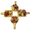 Cuatro mini tablas de madera, dos redondas y dos cuadradas, dispuestas en cruz y decoradas con aperitivos y frutas.