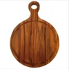 Tabla circular de madera de teca natural con mango y orificio para colgar, vista desde arriba mostrando vetas contrastantes.