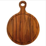 Tabla circular de madera de teca natural con mango y orificio para colgar, vista desde arriba mostrando vetas contrastantes.