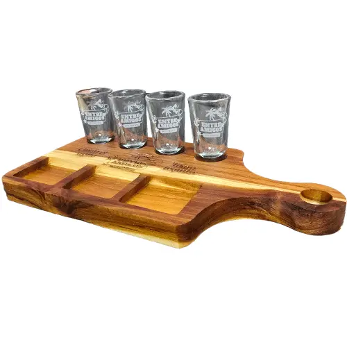 Tabla de madera de teca para servir tequila en ángulo, con cuatro vasos tequileros de vidrio, tres compartimentos cuadrados para sal y limón, y grabado láser.