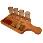 Vista en ángulo de tabla tequilera de madera maciza de Santos Customs Designs, equipada con 4 caballitos, compartimentos con sal y limón, y grabado de las Fases del Tequila.