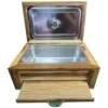 caja-madera-asador-acero-frontal.webp Vista frontal de una caja térmica de madera para asador de Santos Customs Designs, mostrando la tapa abierta, el amplio interior de acero inoxidable y la tabla inferior de madera totalmente extraída.