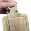 Mano sosteniendo una mini tabla de madera rectangular que presenta un nudo natural oscuro cerca del mango.