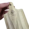 Mini tabla de madera rectangular con un prominente nudo natural cruzando el canal de jugos en la base del mango.