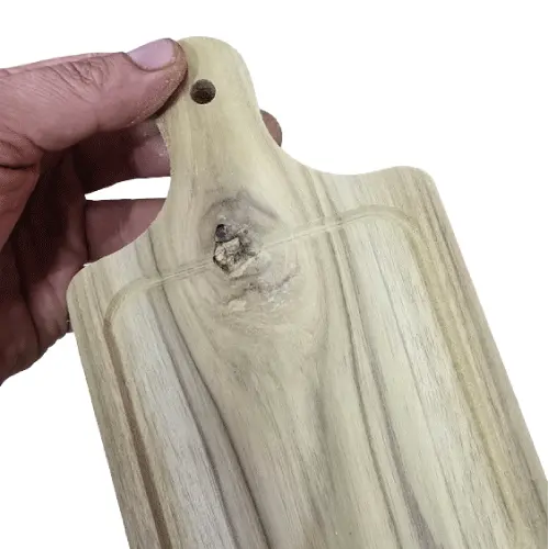 Mini tabla de madera rectangular con un prominente nudo natural cruzando el canal de jugos en la base del mango.